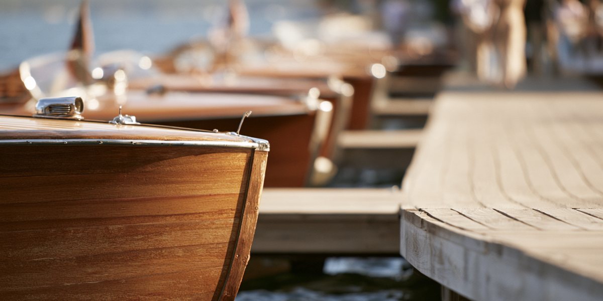 Lake Tahoe Concours d'Elegance Polished wooden classic boats lined up along a lakeside dock