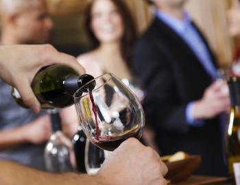 People gather round a table to taste wine