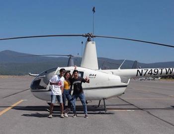 people standing next to a helicopter