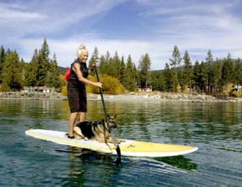 woman and dog on a stand up paddle board