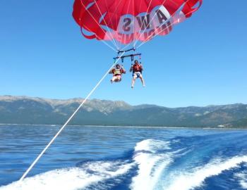 two people parasailing behind boat