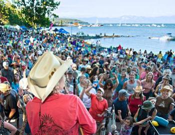 large gathering of people on the beach watching concert