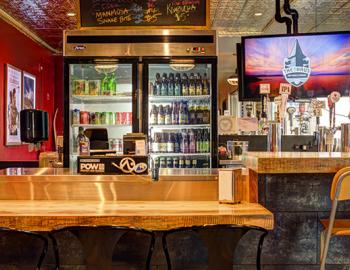 front counter for ordering with refrigerator with drinks in the background