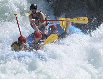 people in rough white water in a large raft