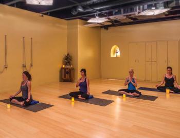 women in a yoga room in a yoga pose