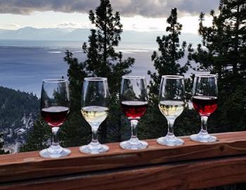 wine glasses on railing with view of lake