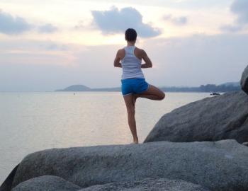 woman on rock in a yoga pose