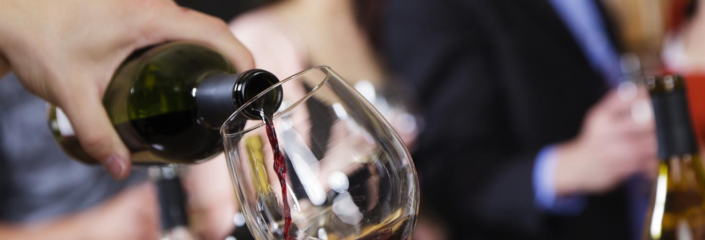 A group of people gather round a table to taste wine