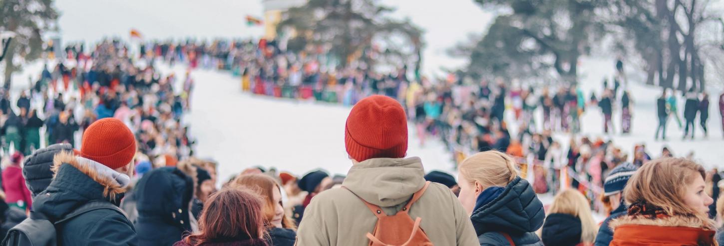 A crowd of people gather in the snow