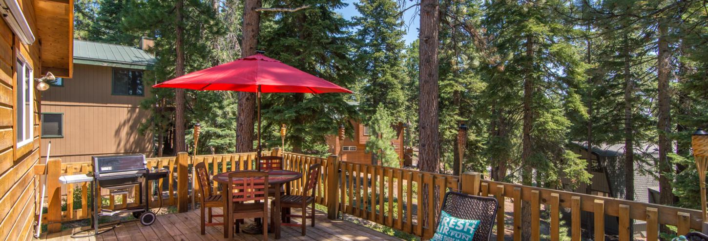 outdoor dining table with large red umbrella