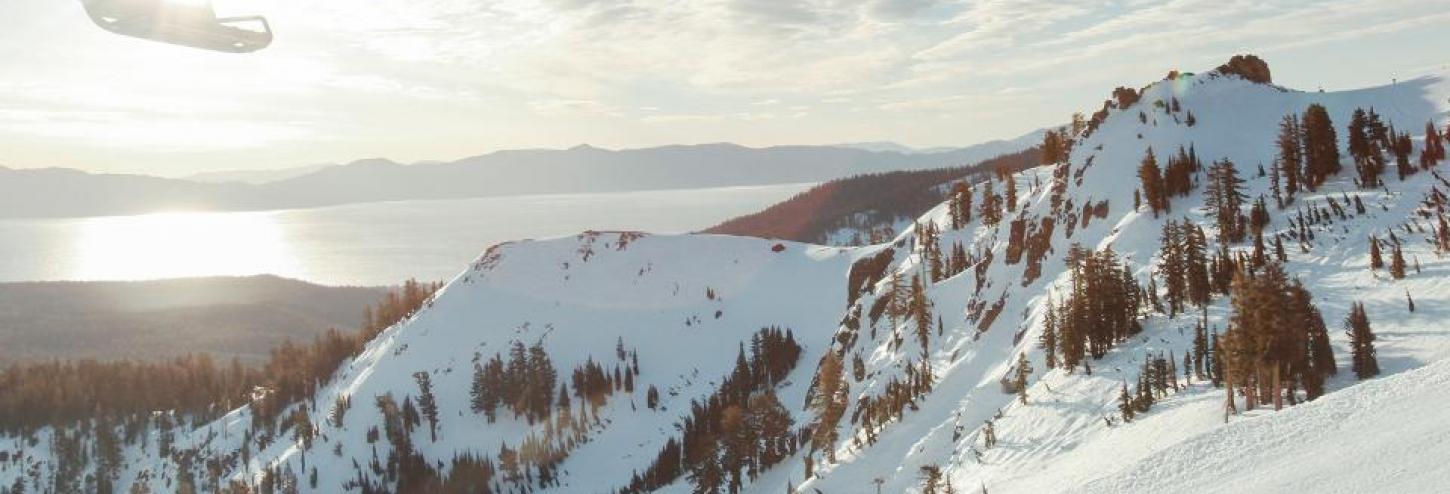 Fresh snow on mountain tops, view of lake from top of snow capped mountain