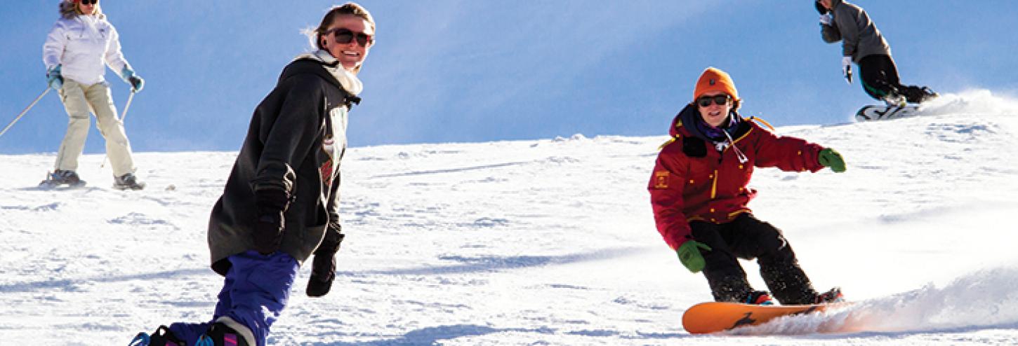 two people snowboarding down a mountain