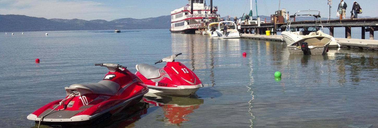 jet skis and docked boat in background