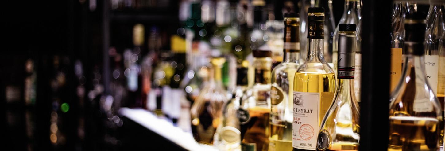 bottles of liquor on shelf at back of bar