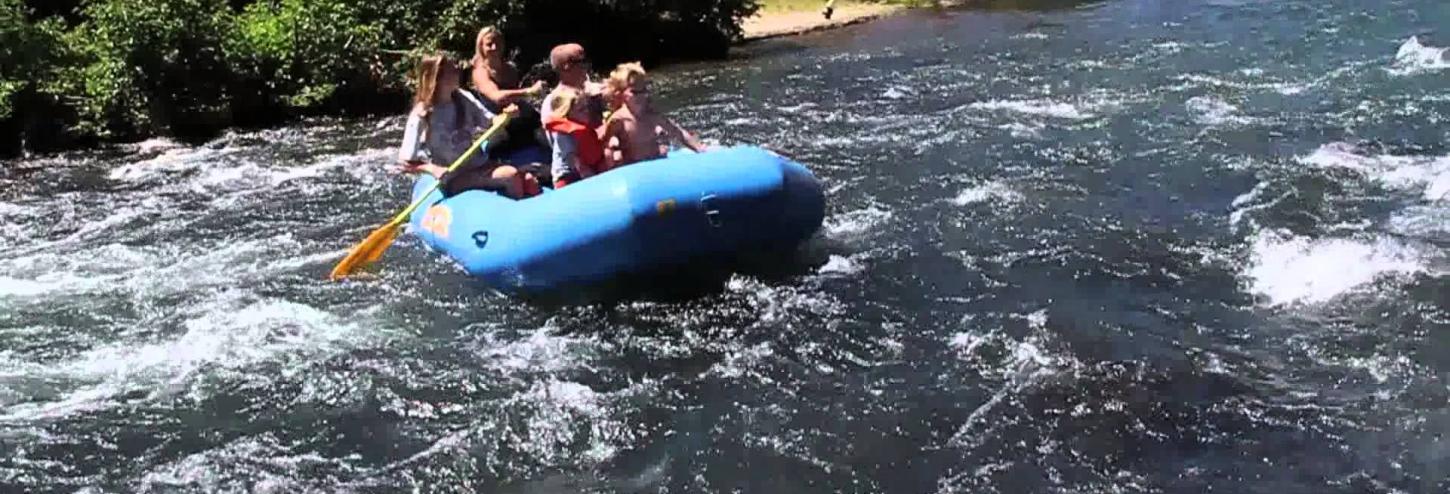 rafters in large blue raft going down the river