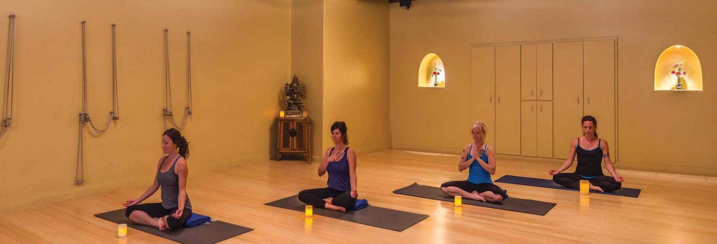 women in a yoga room in a yoga pose