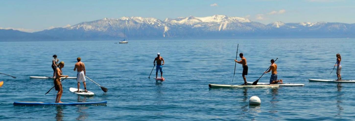 many people on stand up paddle boards in tahoe