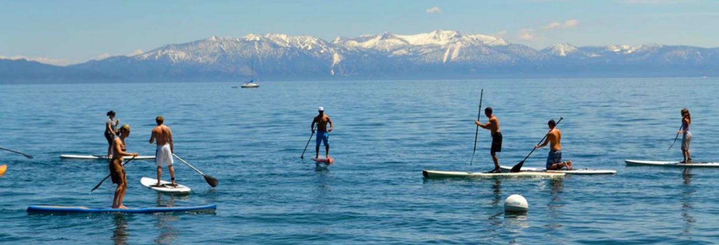 many people on stand up paddle boards in tahoe