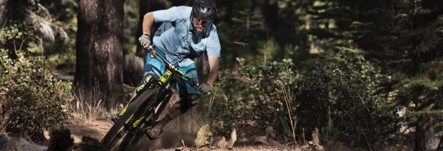 man riding a mountain bike downhill wearing a helmet