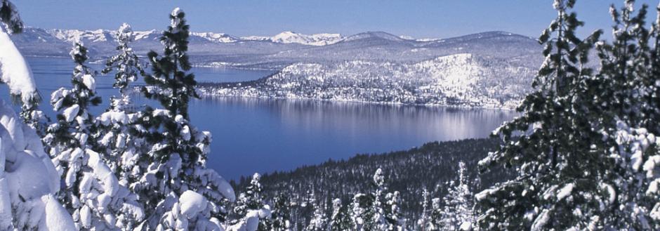 Blue skies with snow capped mountains, view of fresh snow on mountain from across the lake