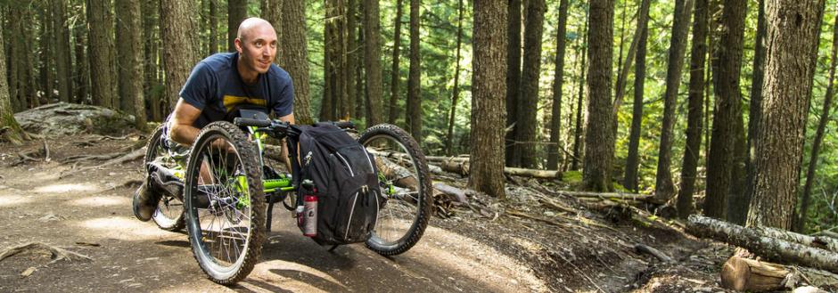 man in racing wheelchair in the woods