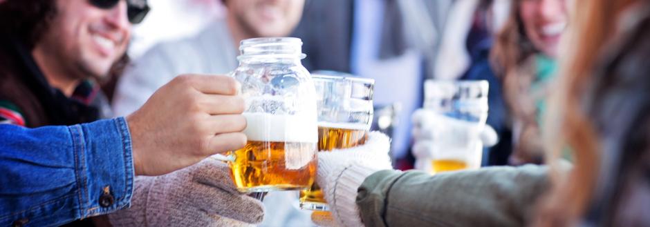 people holding glasses of beer together in a cheers