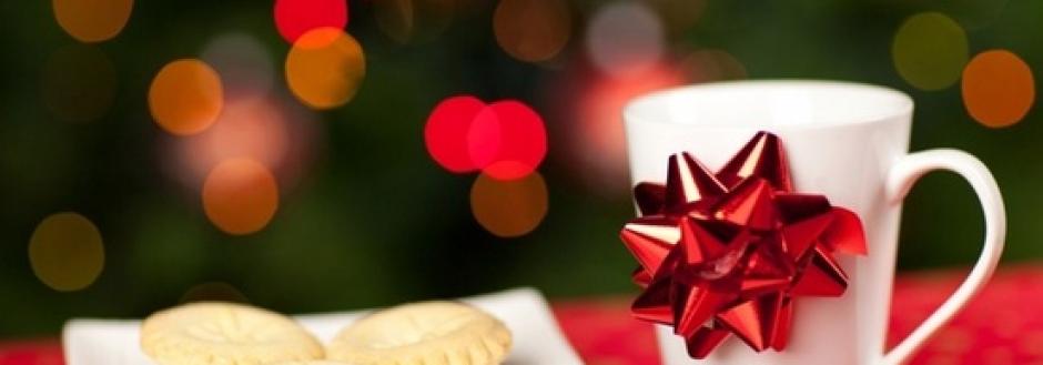 white cup with red ribbon next to a plate of snacks for sants