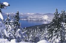 Blue skies with snow capped mountains, view of fresh snow on mountain from across the lake