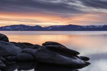 sunset over tahoe with large boulders in the forefront