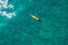 stand up paddle boarding on emerald colored lake