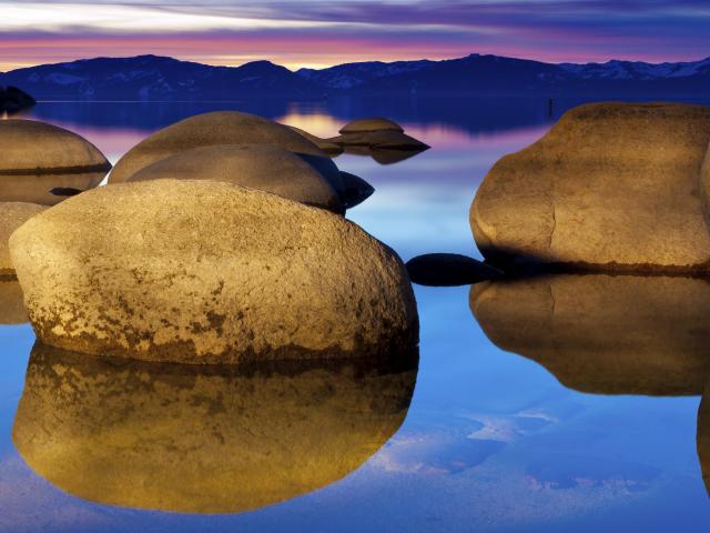 large boulders on the lake at sunset