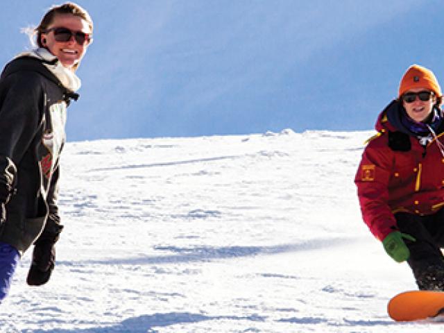 two people snowboarding down a mountain