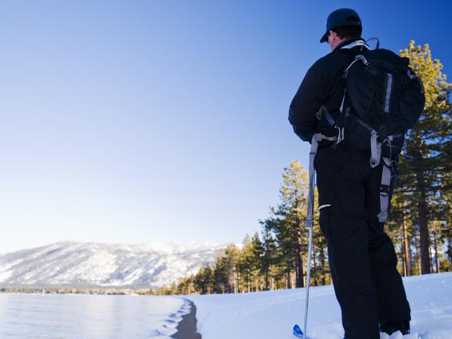 man standing still on skis looking at the snow
