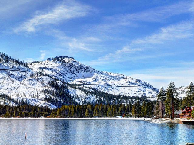 donner lake with snow capped mountains on the other side of the lake