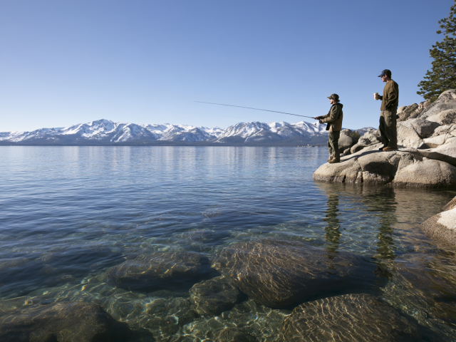 Two fisherman casting out in Lake Tahoe in a crisp spring morning
