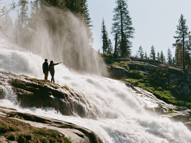 A group of people standing close to a Tahoe waterfall