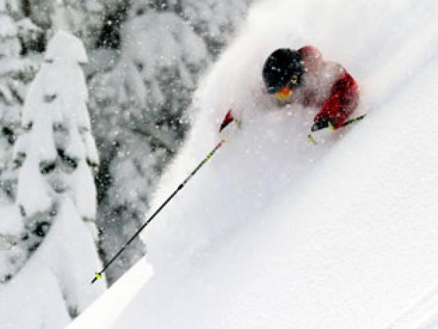 man skiing through fresh powder