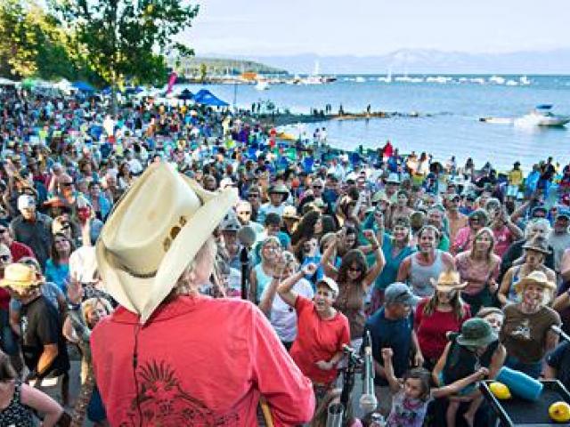 large gathering of people on the beach watching concert