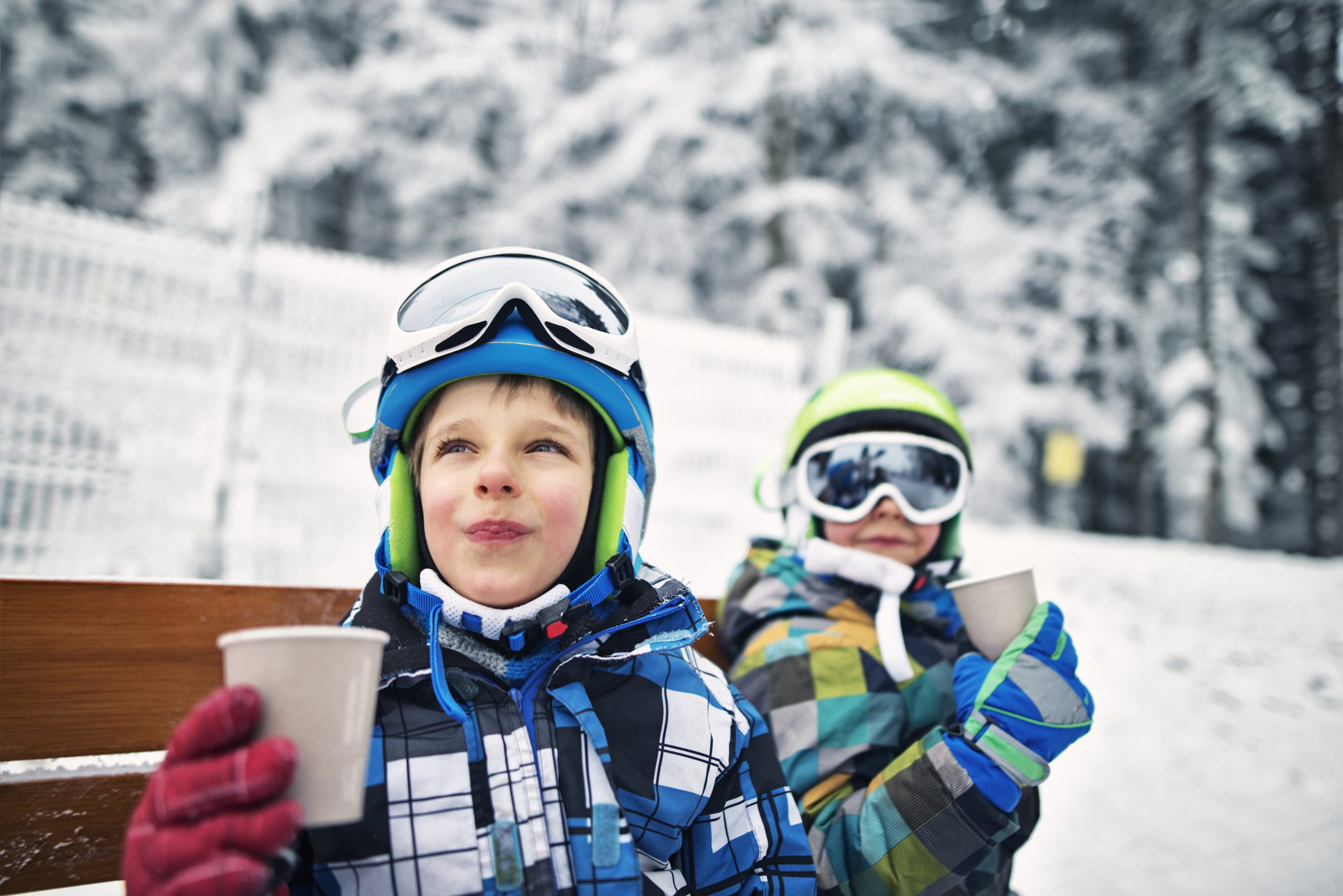 Kids in snow gear drinking hot chocolate